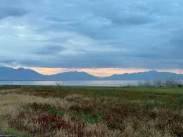 A mountain lake beneath a cloudy blue sky